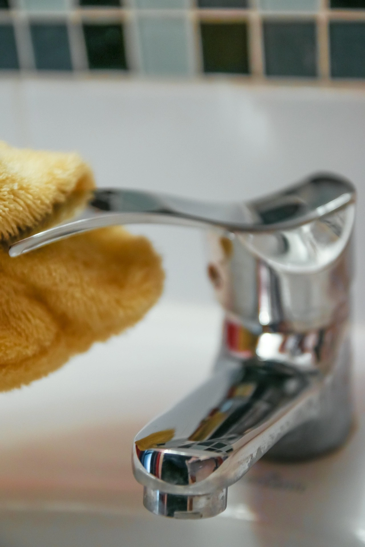 Hand polishing a chrome bathroom faucet with a soft cloth – KD Home Cleaning quality service